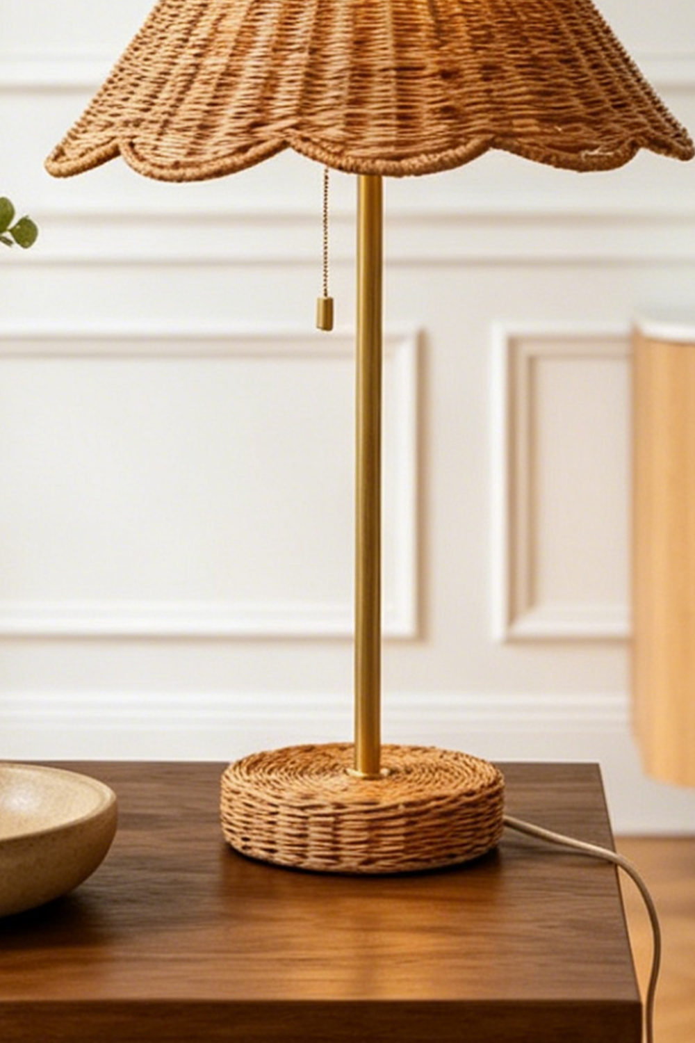 Osrilla Scalloped Rattan Table Lamp | Rattan, Brass | Close-up structural view focusing on the slim gold brass stem, classic pull-chain switch, and matching wrapped rattan base plate | Detail shot | Samu Lamp