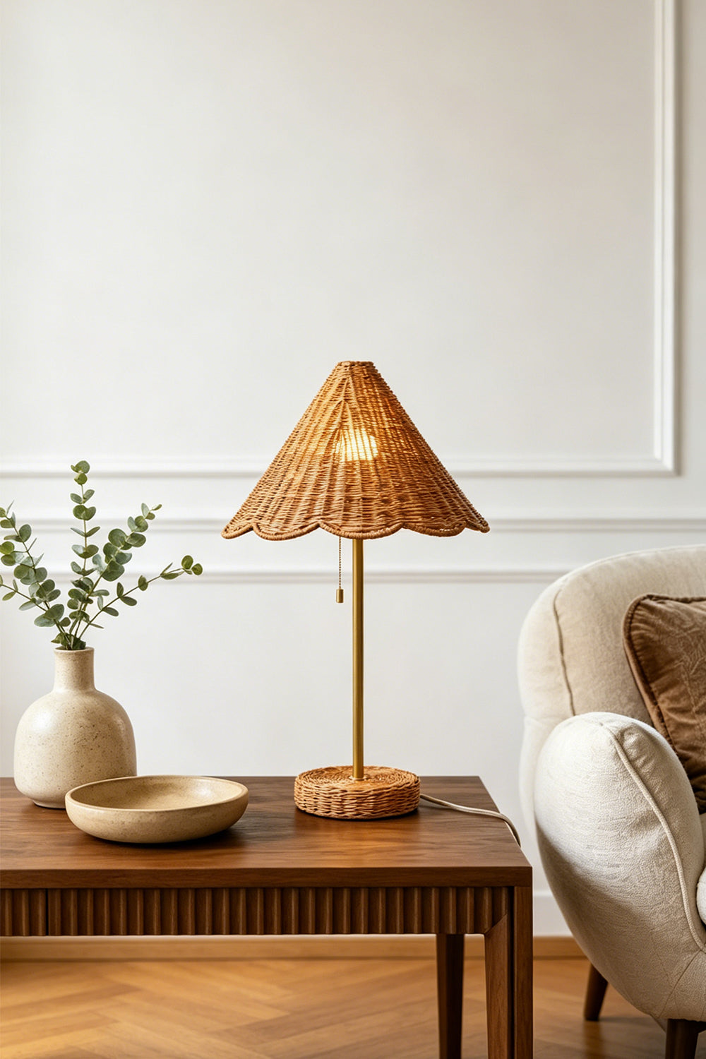 Osrilla Scalloped Rattan Table Lamp | Rattan, Brass | Placed as a charming accent light on a fluted wood bedside table in a room with herringbone hardwood floors and a ceramic vase | Samu Lamp