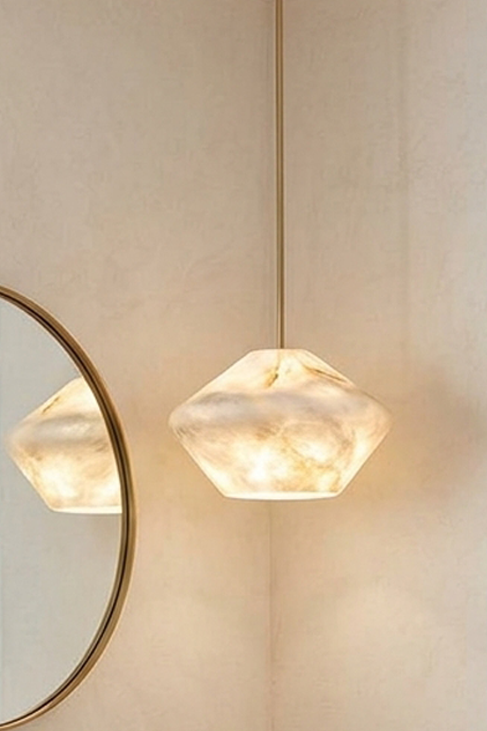 Ottilie Barrel Alabaster Pendant Light | Natural Alabaster and Metal | Close-up view of the wide alabaster shade hanging beside a round wall mirror | Samu Lamp