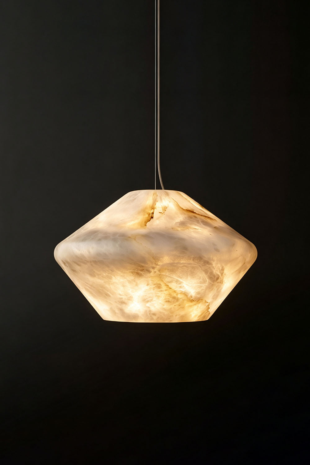 Ottilie Barrel Alabaster Pendant Light | Natural Alabaster and Metal | Studio shot of the illuminated wide alabaster pendant on a dark background | Samu Lamp