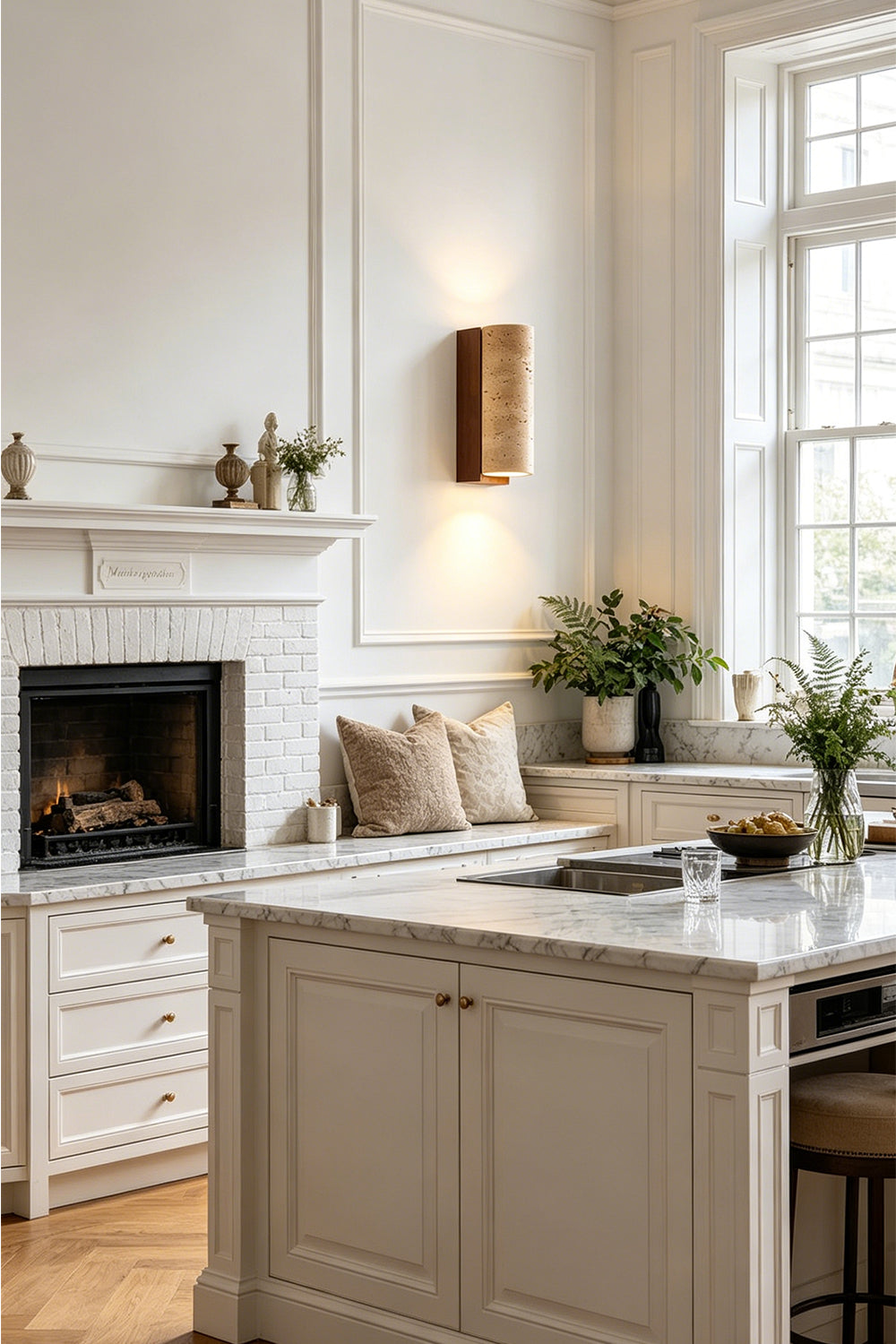 Outcrop Beige Travertine Wall Sconce | Travertine, Metal | Providing cozy ambient illumination on a paneled wall in a contemporary kitchen near a white marble island counter | Samu Lamp