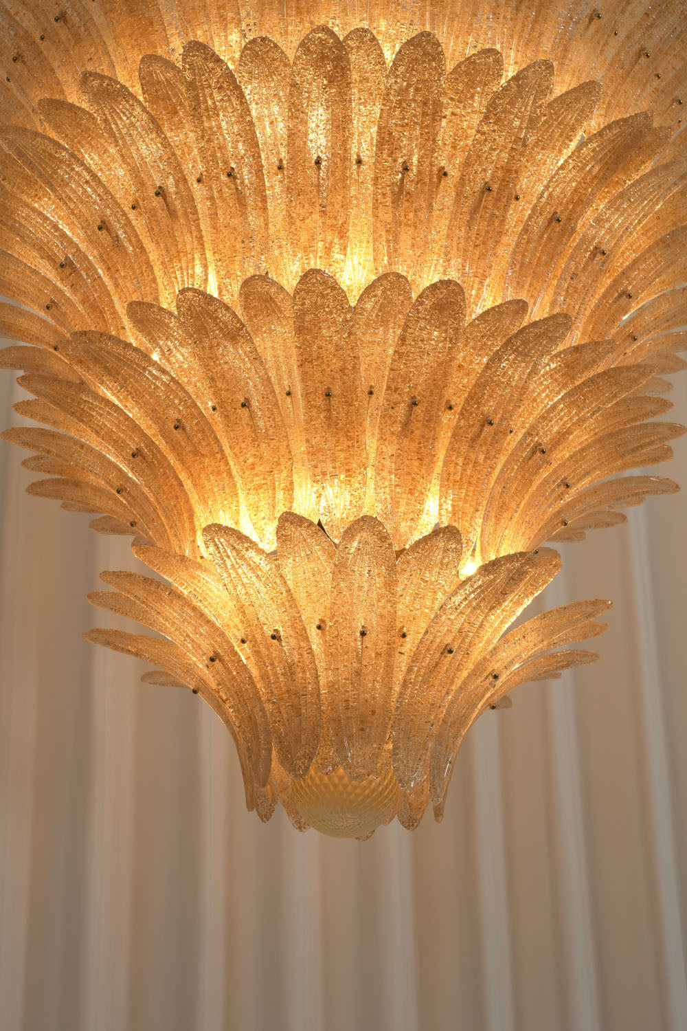 Palmonde Palm Leaf Chandelier | Brass and Amber Glass | Close-up of round brass screw caps securing glass leaf | Samu Lamp