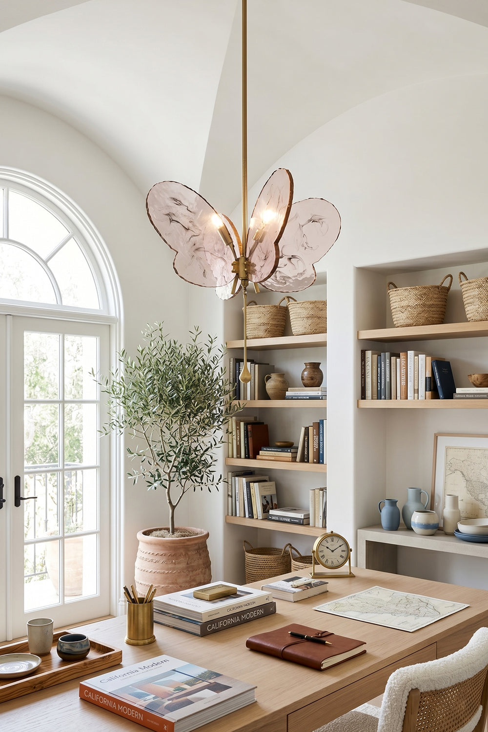 Papillon Glass Butterfly Pendant Lamp | Glass, Metal | Pink variant casting a warm glow in a bright, modern home office workspace above a wooden executive desk | Samu Lamp