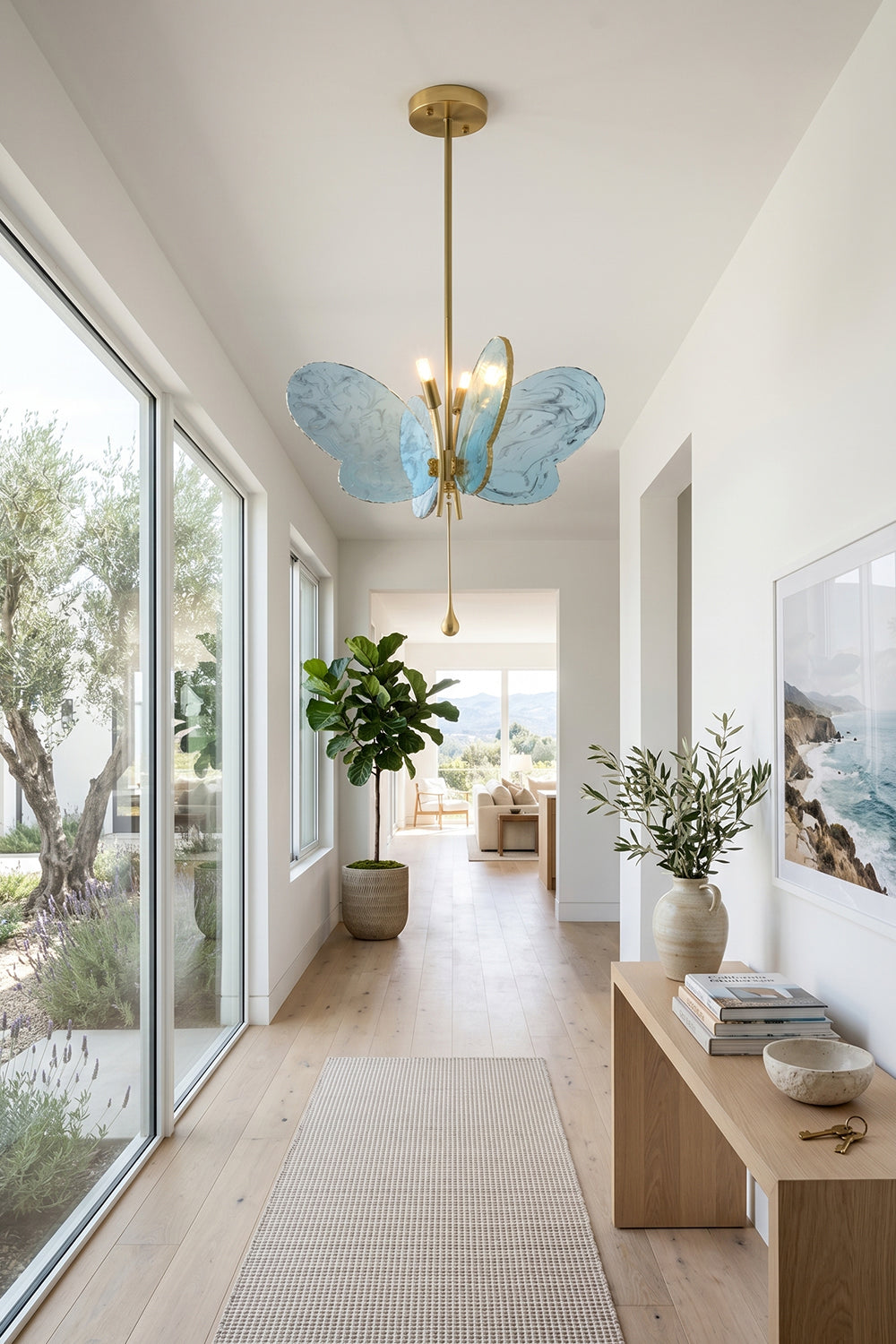 Papillon Glass Butterfly Pendant Lamp | Glass, Metal | Blue glass butterfly pendant installed along a long, bright minimalist hallway with sliding glass doors | Samu Lamp