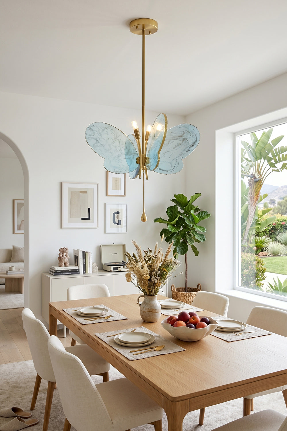 Papillon Glass Butterfly Pendant Lamp | Glass, Metal | Blue variant suspended over a light wood dining table and chairs in a contemporary sunlit dining room | Samu Lamp