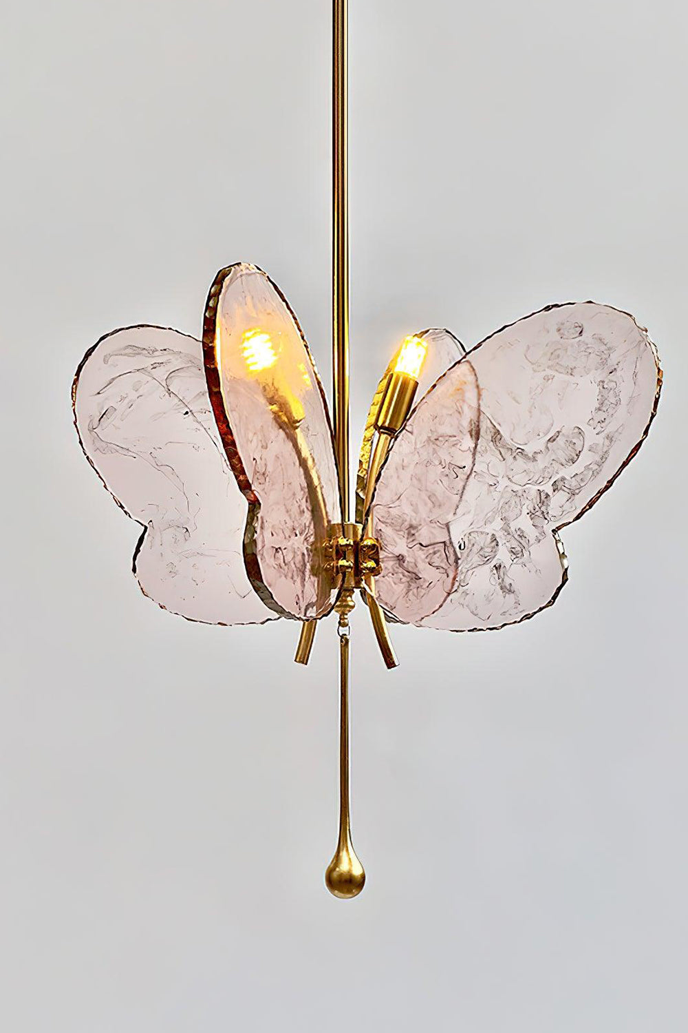 Papillon Glass Butterfly Pendant Lamp | Glass, Metal | Side angled view of the glowing pink glass wings and polished gold brass rod fixture | Samu Lamp