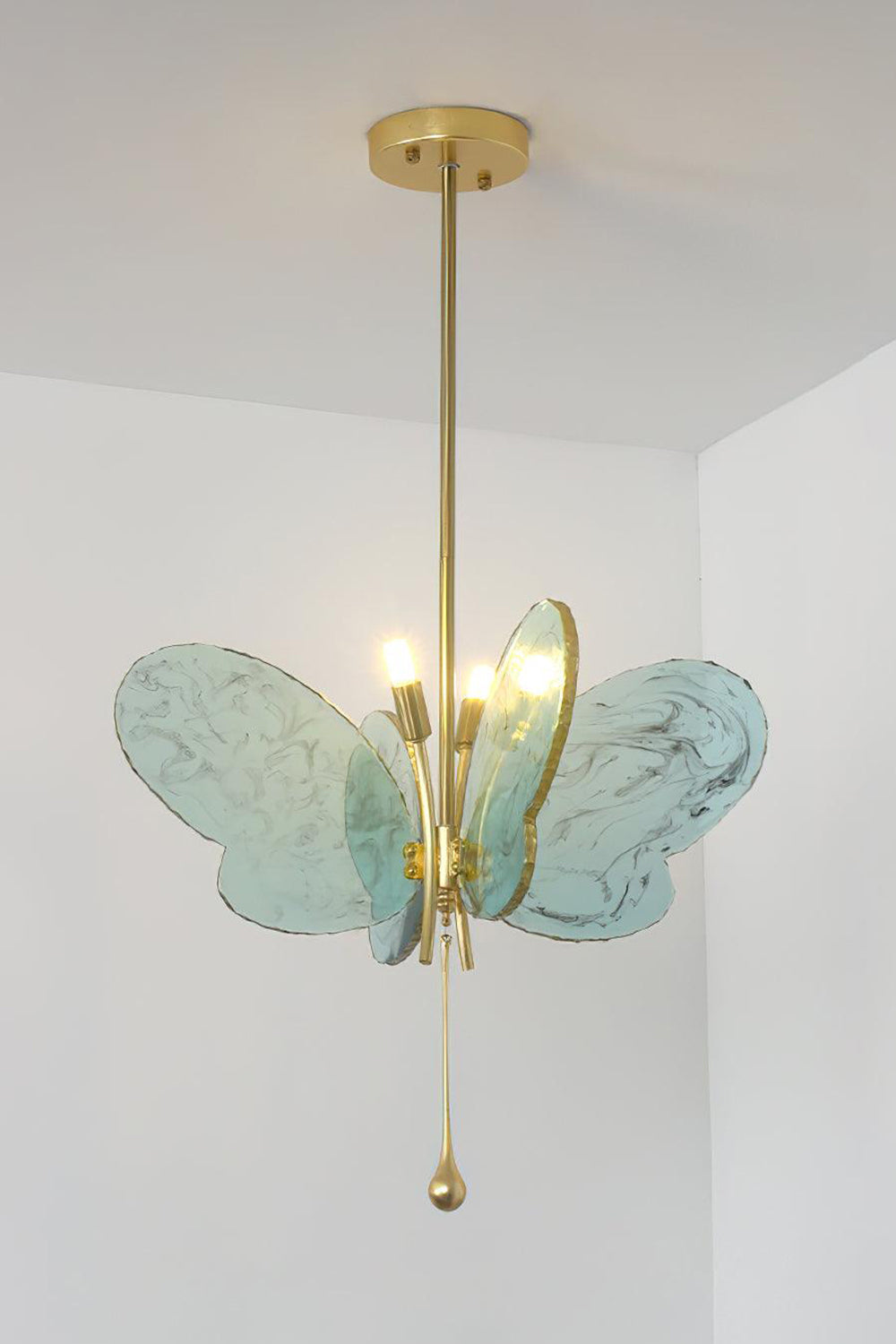 Papillon Glass Butterfly Pendant Lamp | Glass, Metal | Front view of the fully lit blue glass butterfly variant radiating soft ambient light against a neutral studio wall | Samu Lamp