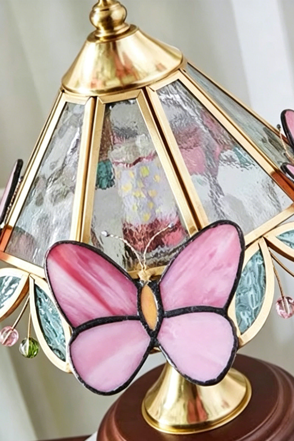 Papillon Heirloom Stained Table Lamp | Wood, Glass, Metal | Close-up angled view showcasing the vibrant translucent pink stained glass butterfly embellishment | Detail shot | Samu Lamp