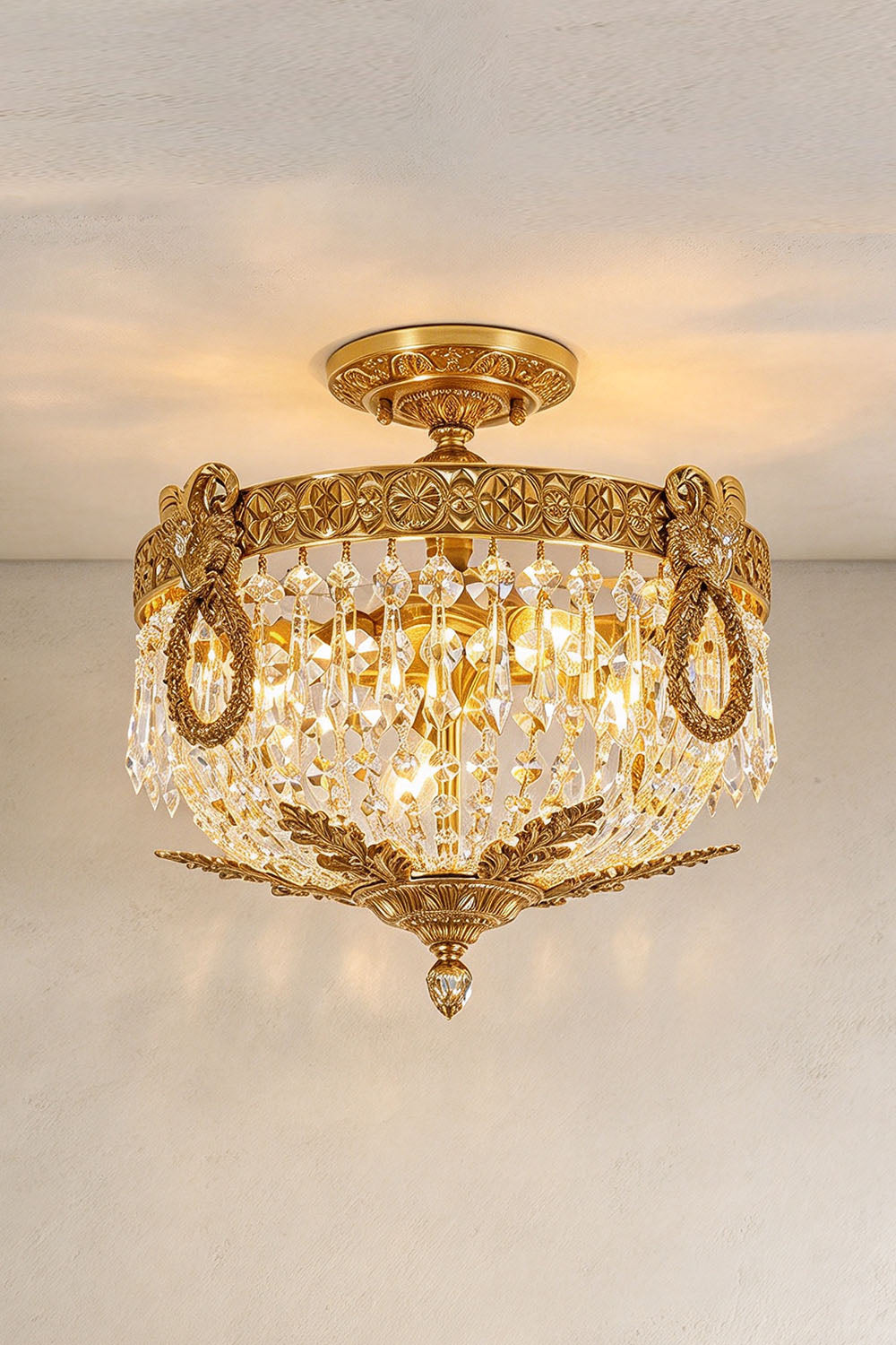 Pellerine Brass Wreath Crystal Semi-Flush Ceiling Light | Cut Crystal and Brass | Full product view glowing softly against a plain neutral wall backdrop | Samu Lamp