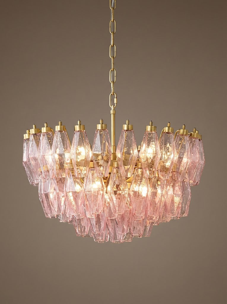 Lit pink tiered glass chandelier against dark background | Metal, Glass | Detailed front view showing the prismatic glow | Samu Lamp