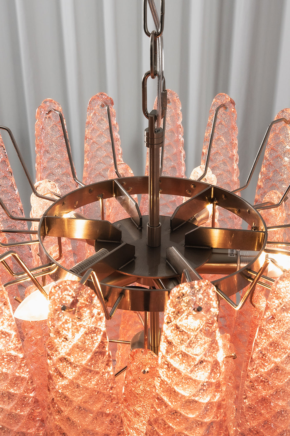 Amara Blush Cascading Glass Chandelier | Glass, Metal | Internal top-down view showing the lit bulbs and the concentric silver metal ring frame holding the glass | Detail shot | Samu Lamp