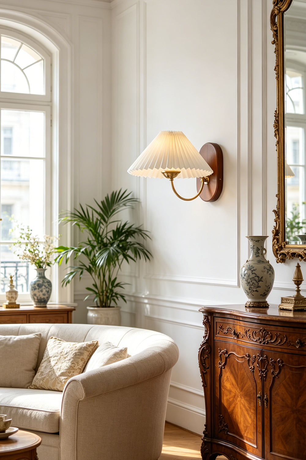 Pleated Fabric Wall Lamp | Fabric, Metal, Wood | Mounted on a wall as accent lighting in a classic living room with a tufted cream sofa and a large arched window | Samu Lamp