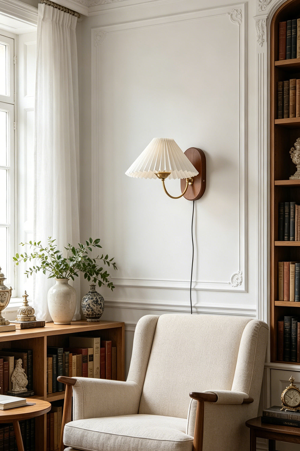 Pleated Fabric Wall Lamp | Fabric, Metal, Wood | Providing a cozy warm glow over a fabric armchair in a bright reading corner next to a wooden bookshelf | Samu Lamp