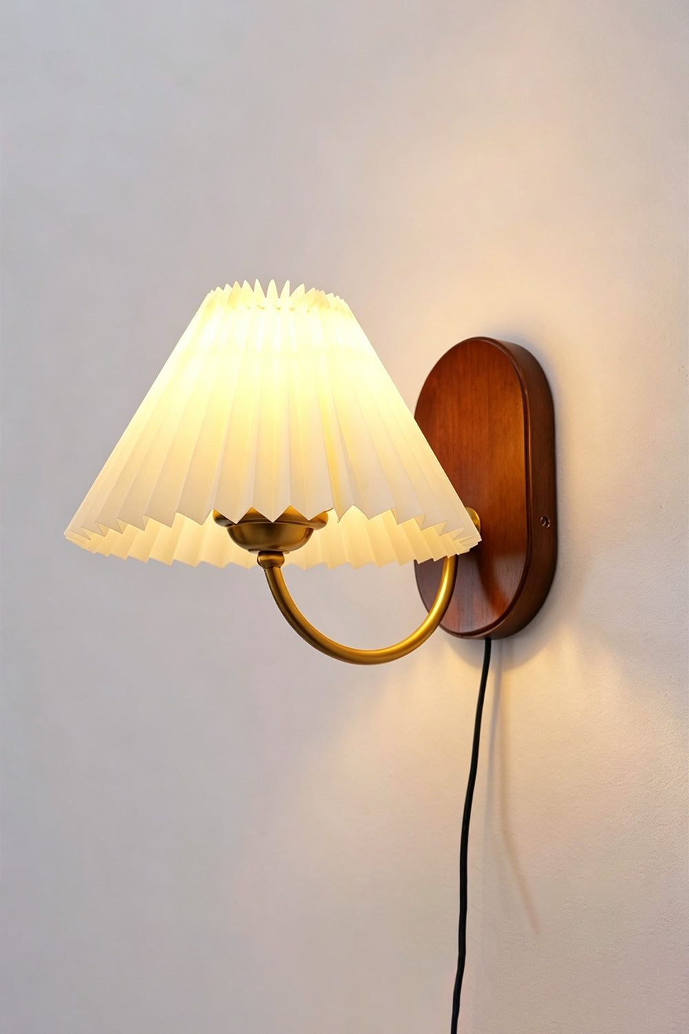 Pleated Fabric Wall Lamp | Fabric, Metal, Wood | Frontal angled view of the fully lit vintage pleated sconce throwing a warm golden backlight halo onto a neutral wall | Isolated shot | Samu Lamp