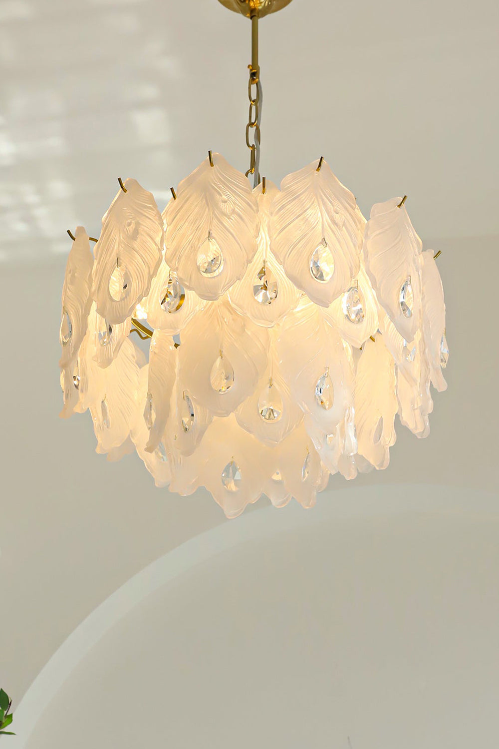 Pluma Frosted Glass Feather Chandelier | Glass, Metal | Clean front studio view of the fully illuminated glass feather fixture casting a soft warm backlight halo against a plain background | Samu Lamp