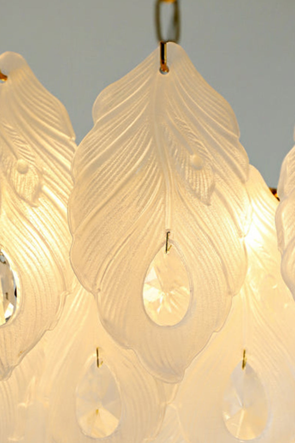 Pluma Frosted Glass Feather Chandelier | Glass, Metal | Macro close-up focus on the illuminated textured frosted white glass feathers and clear dangling crystal teardrops | Detail shot | Samu Lamp