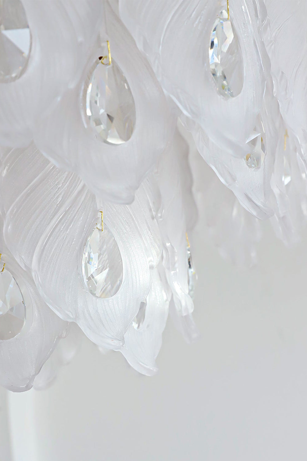 Pluma Frosted Glass Feather Chandelier | Glass, Metal | Detailed close-up profile showing the overlapping layered frosted glass feather panels and smooth clear crystal pendants under bright studio light | Detail shot | Samu Lamp