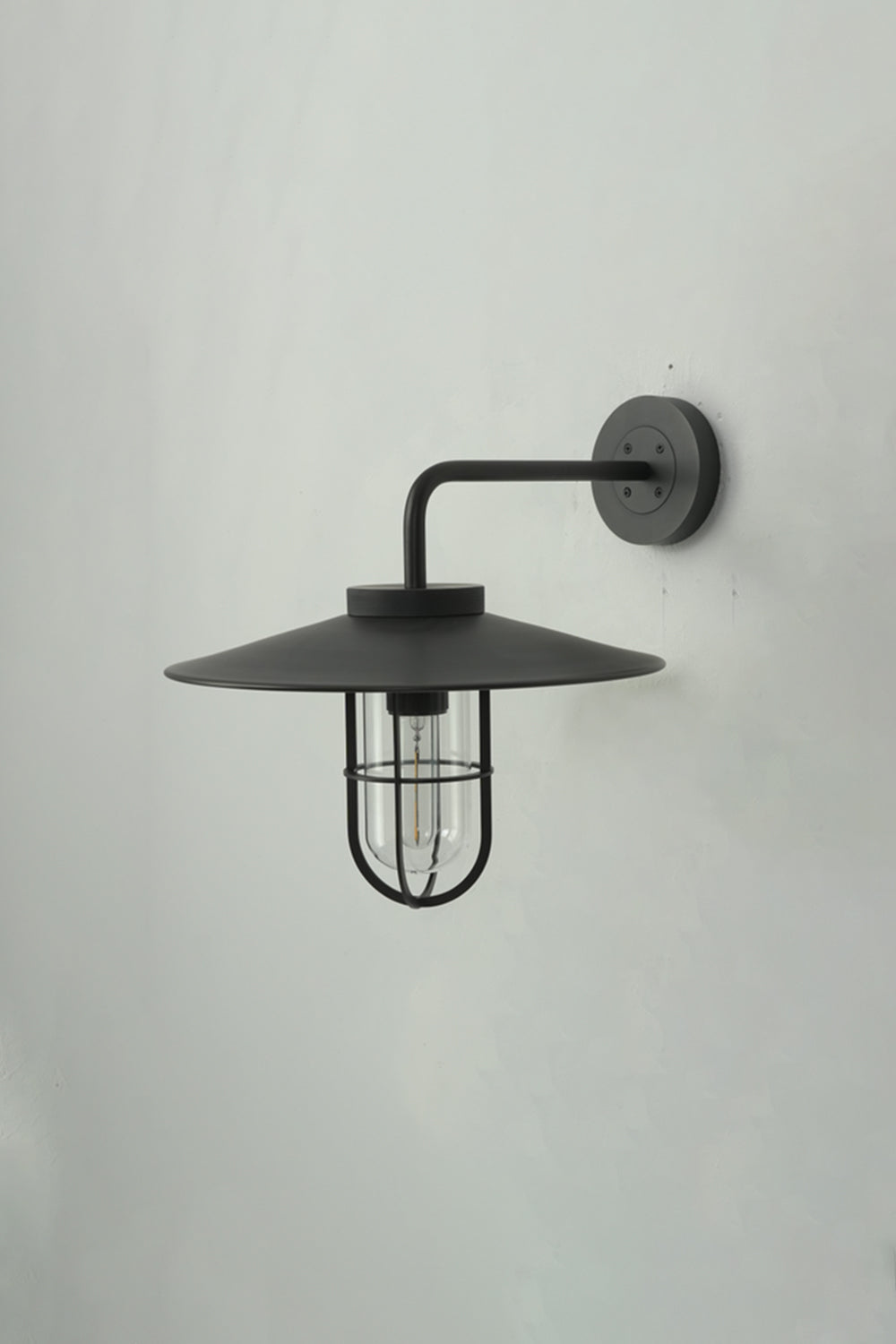 Side profile of black Portree wall light | Metal, Glass | Mounted on a wall showing the gooseneck shape | Samu Lamp