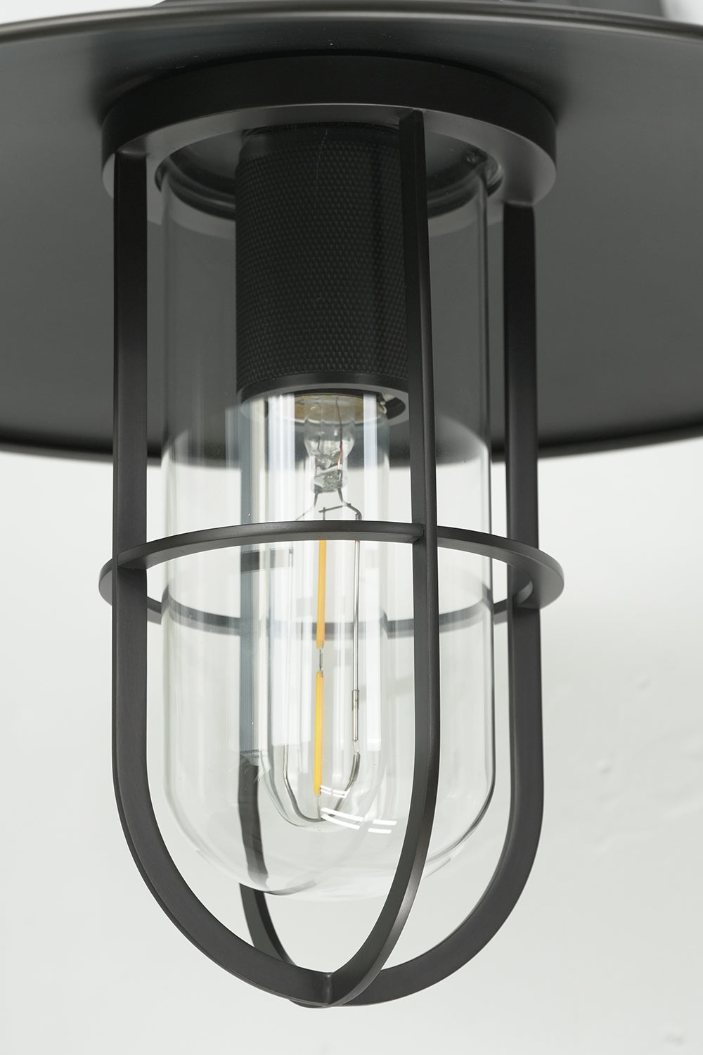 Bottom-up view of black cage and Edison bulb | Metal, Glass | Close-up of the light source and cage protector | Samu Lamp
