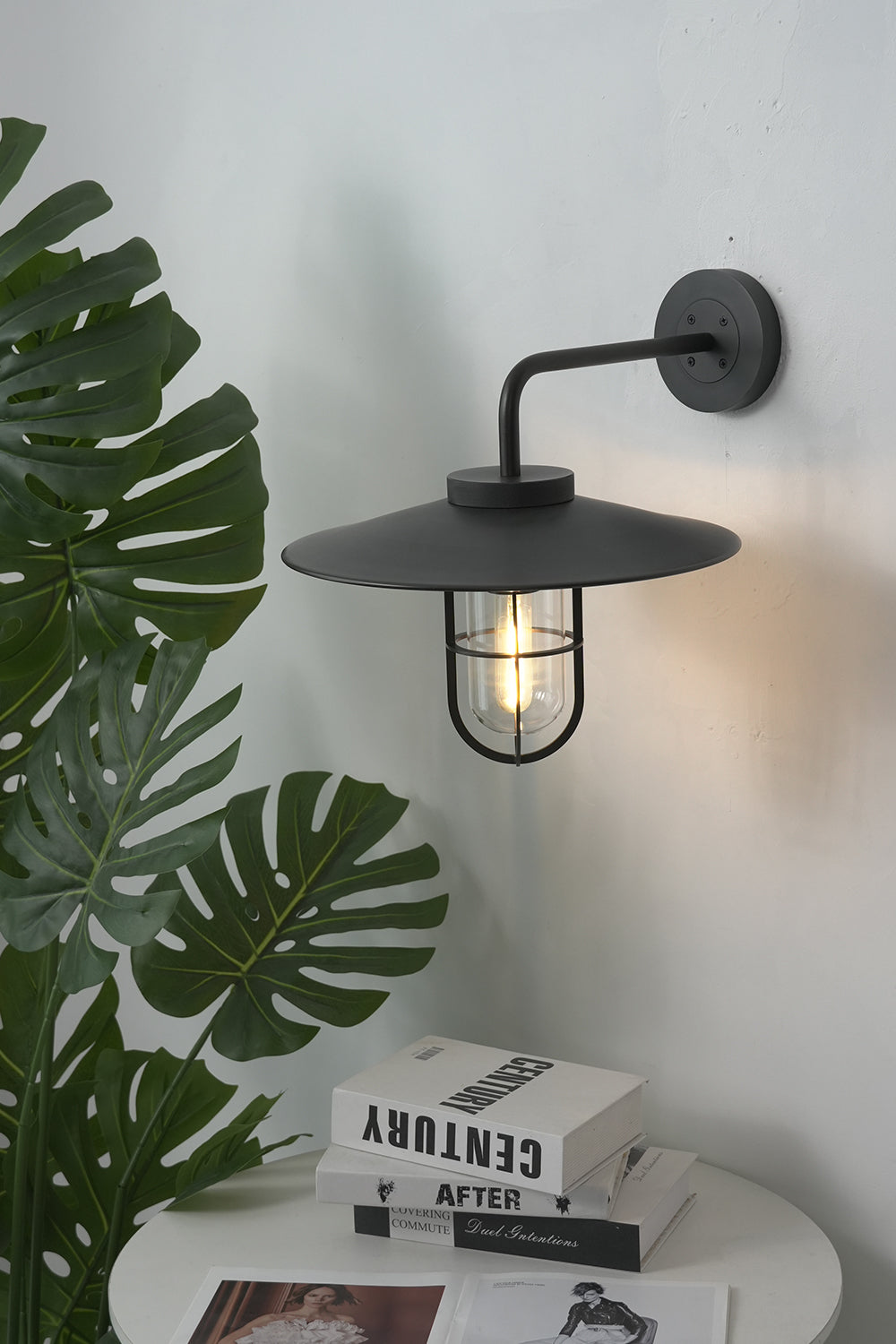 Black Portree wall lamp in a modern interior | Metal, Glass | Mounted near indoor plants and books | Samu Lamp