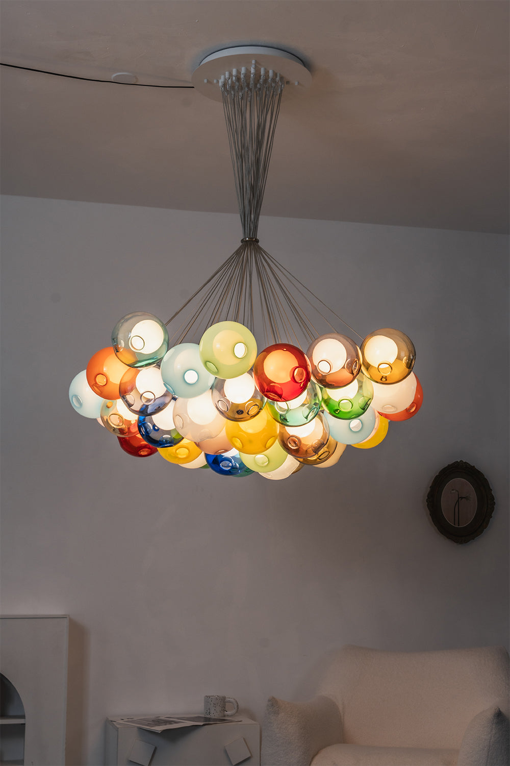 Rainbow Glass Bubble Cluster Chandelier | Glass, Metal | Atmospheric view of the chandelier fully lit in a dark room, showcasing the vibrant glowing colors of the glass spheres | Samu Lamp