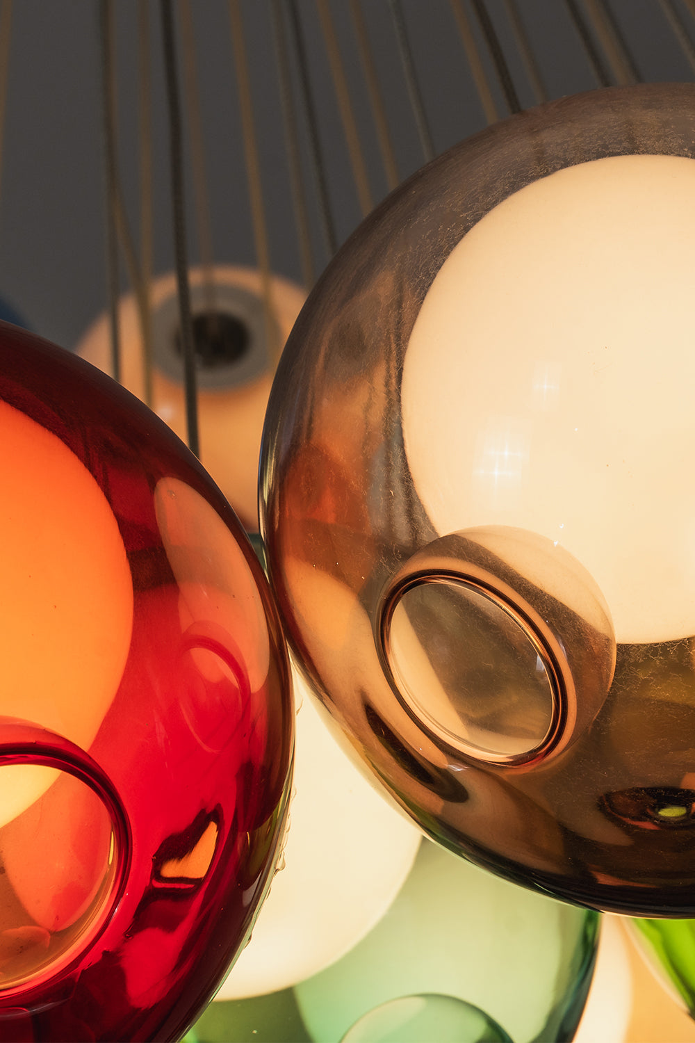 Rainbow Glass Bubble Cluster Chandelier | Glass, Metal | Macro close-up focus on the glossy reflective surfaces of interlocking red, amber, and orange glass bubble globes | Detail shot | Samu Lamp