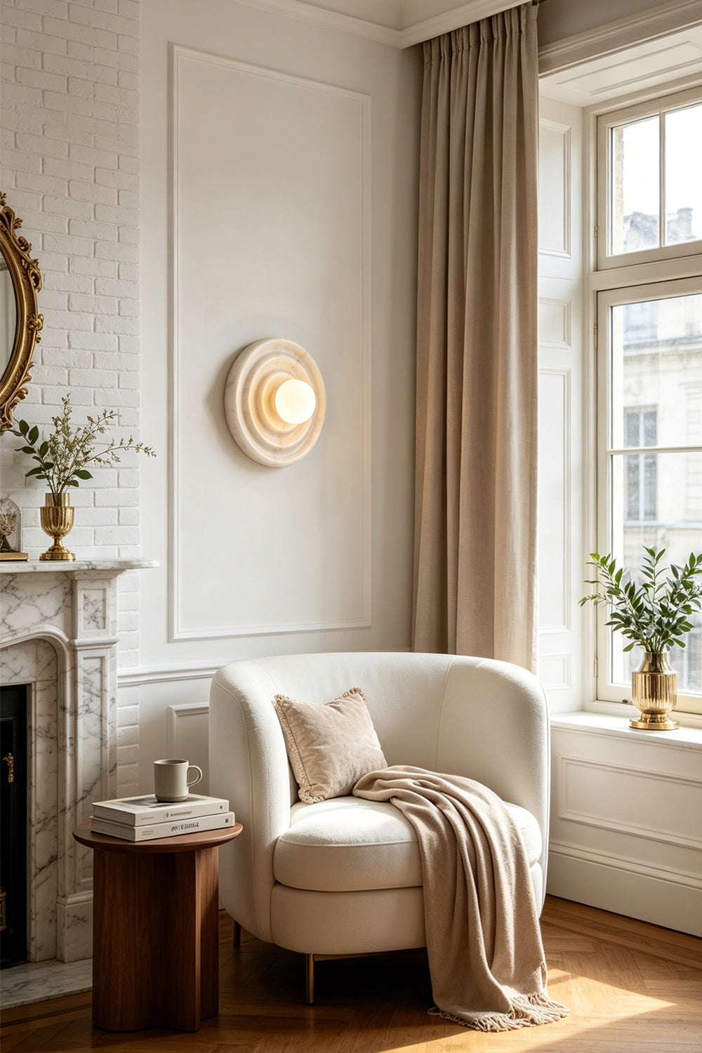 Rhea Rippled Alabaster Wall Sconce | Cozy Reading Nook | Mounted elegantly on a white wall casting a soft warm golden halo over a plush cream armchair and wooden side table in a classical room layout | Samu Lamp