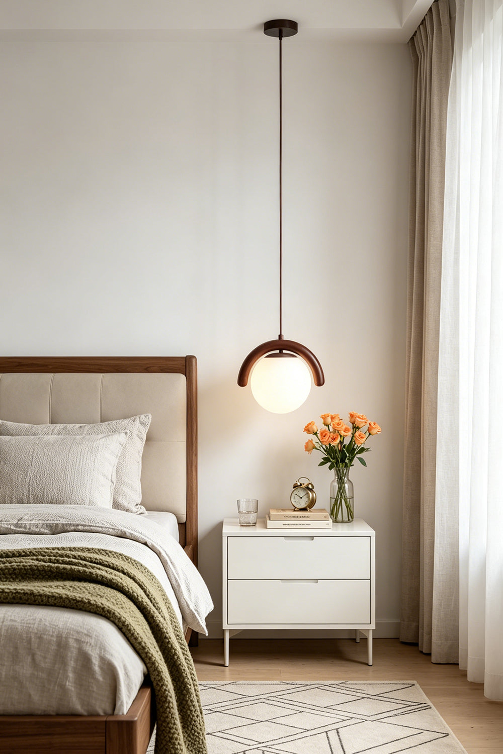 Modern single globe pendant light in a cozy bedroom | Metal, Glass | Installed over a white bedside table with flowers | Samu Lamp