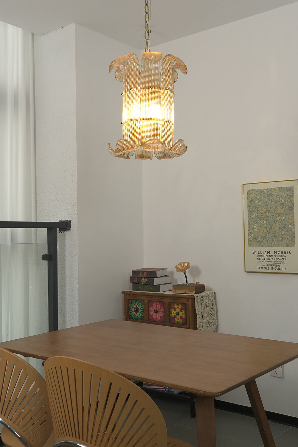 Lit ribbed glass scroll chandelier | Metal | Glass | Low-angle view looking up at the warm glowing frame | Samu Lamp