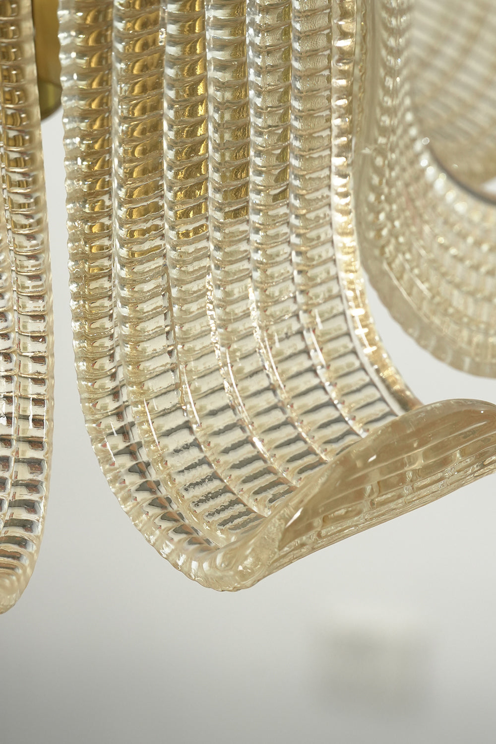 Close-up detail view of the ribbed glass texture | Glass | Showing the clarity and distinct scroll shape of the wall lamp | Samu Lamp