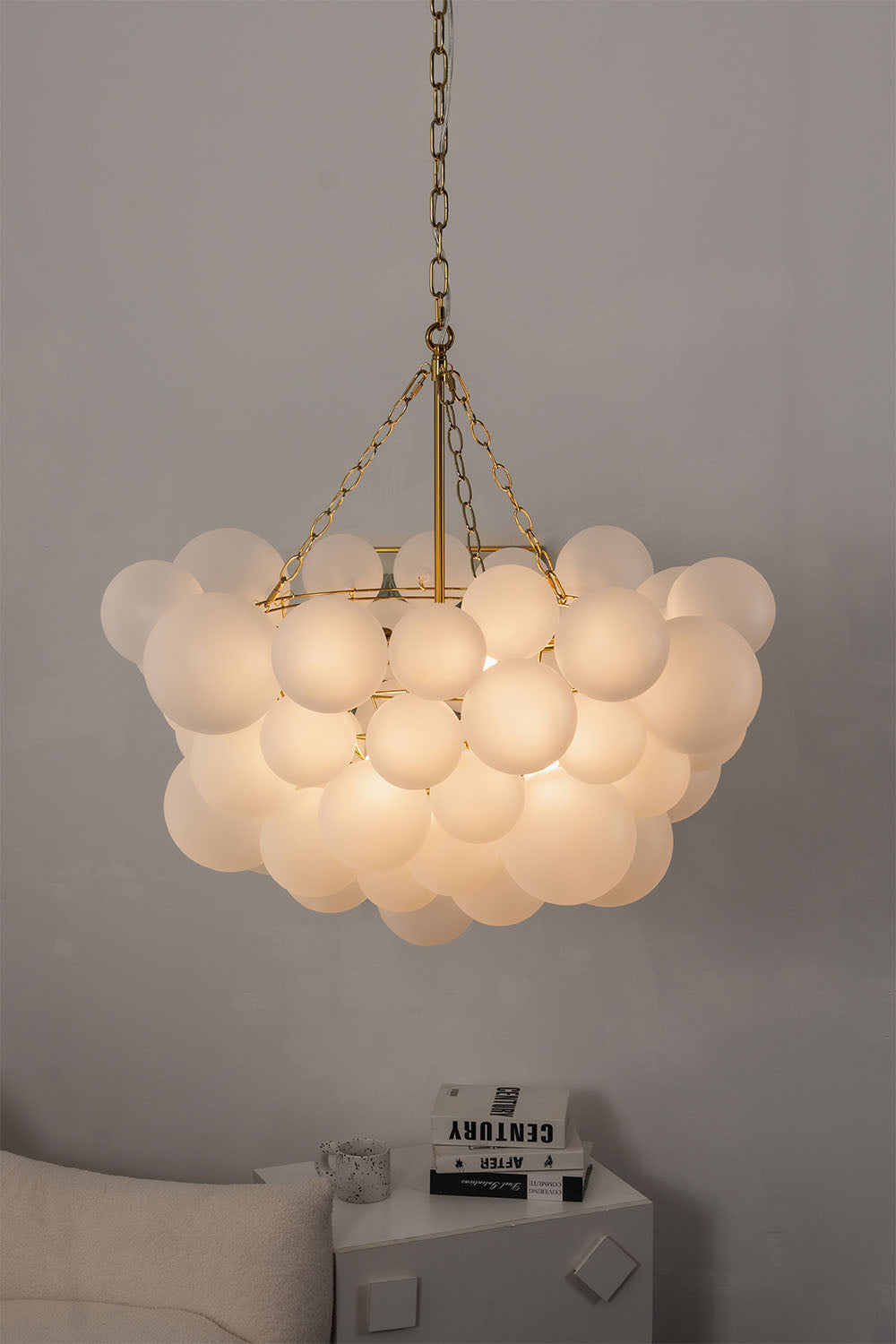 Romilly Frosted Globe Cluster Chandelier | Frosted Glass and Brass | Side angle view of the illuminated chandelier in a modern minimalist setting | Samu Lamp