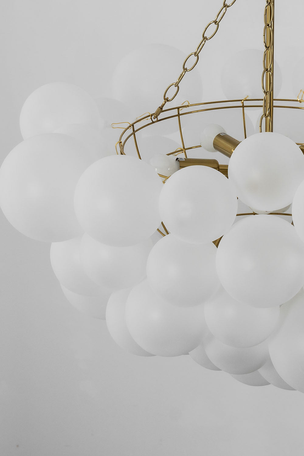 Romilly Frosted Globe Cluster Chandelier | Frosted Glass and Brass | Macro close-up of the unlit white frosted glass spheres | Samu Lamp