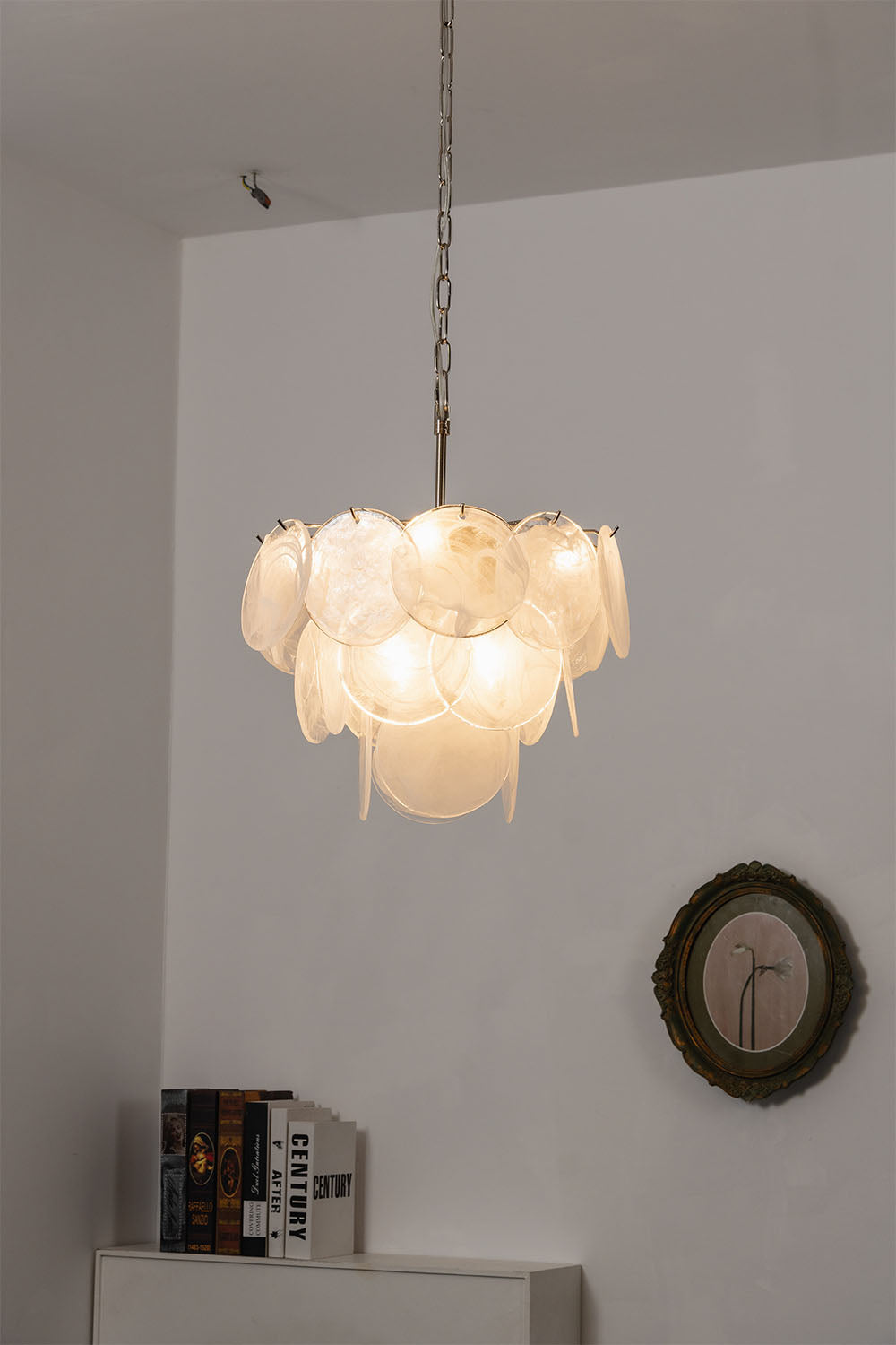 Romilly Layered Glass Disc Chandelier illuminating a stylish interior with its unique design and warm light.
