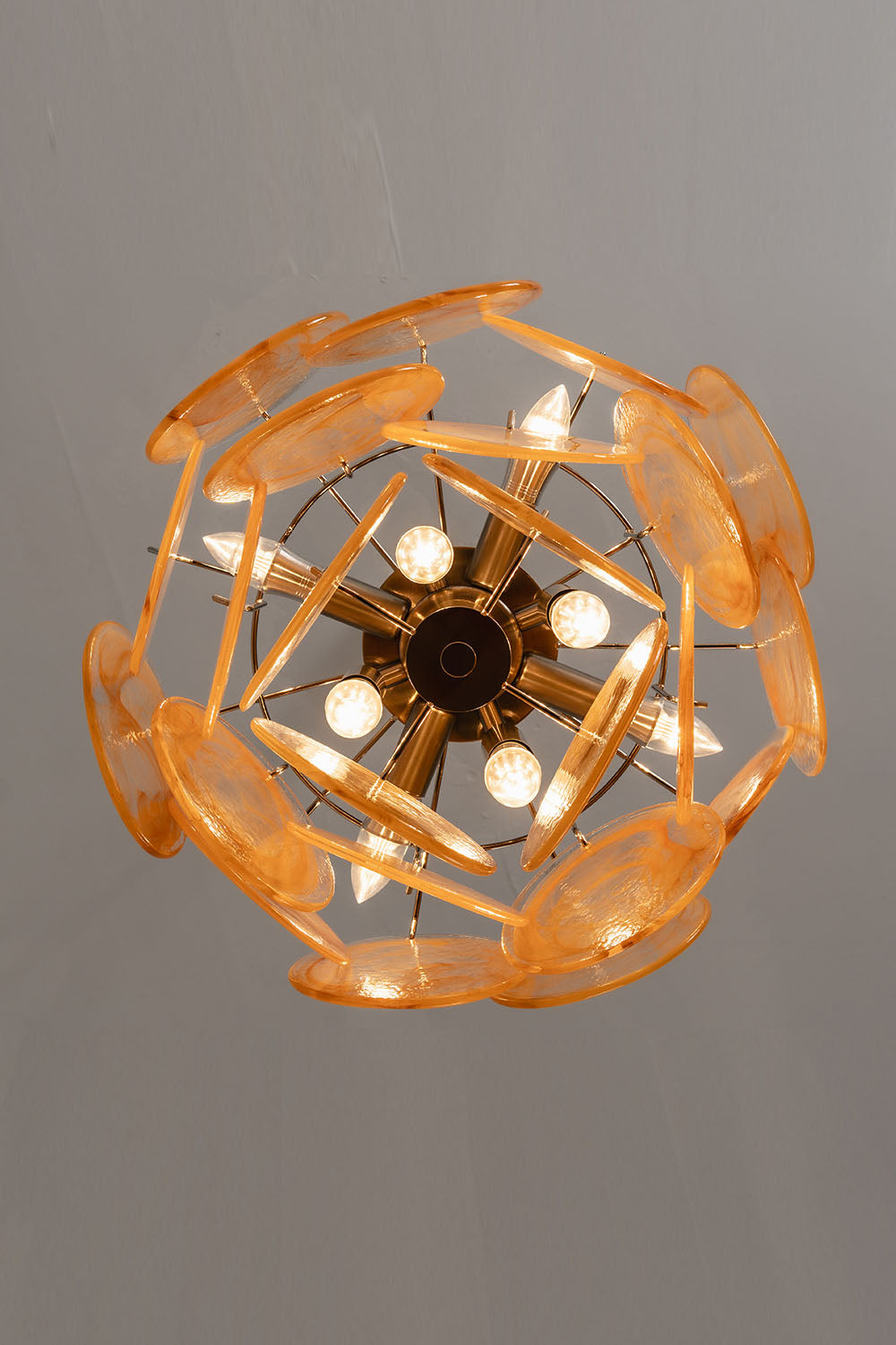 Romilly Layered Glass Disc Chandelier illuminating from above with golden glass discs and a modern design.