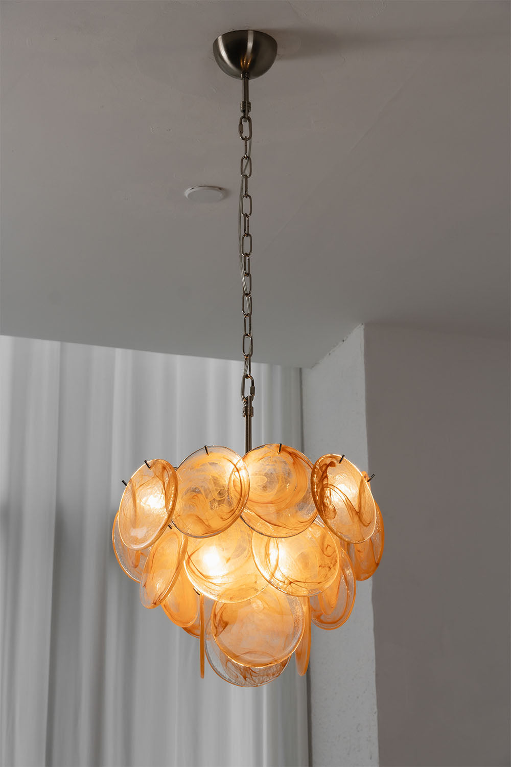 Romilly Layered Glass Disc Chandelier featuring elegant layered glass discs and a warm glow.