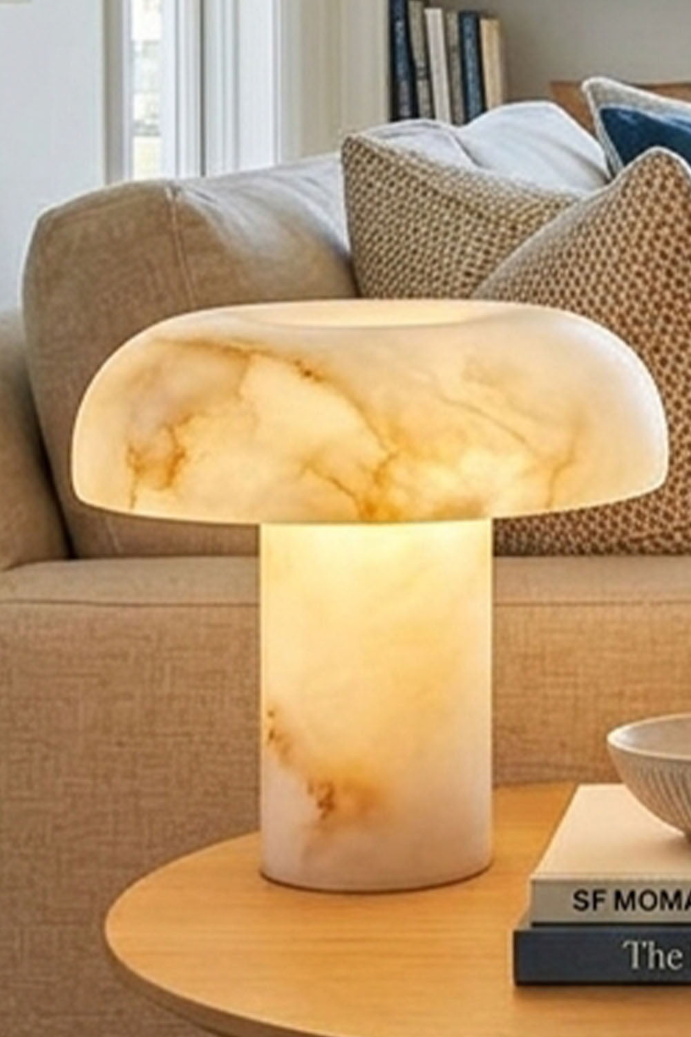 Rosalind Alabaster Dome Table Lamp | Natural Alabaster and Brass | Placed on a round side table beside a sofa in a modern setting | Samu Lamp
