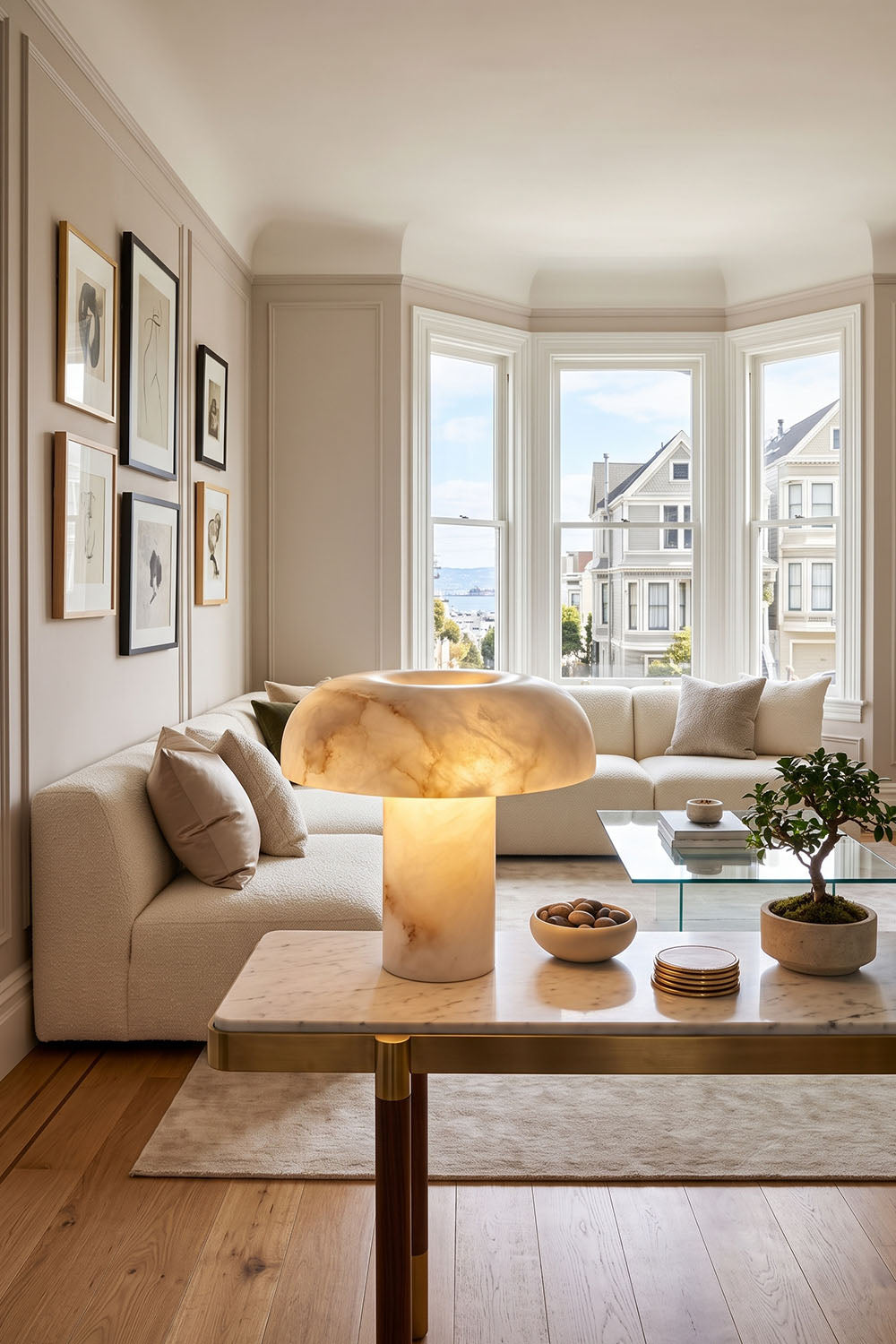 Rosalind Alabaster Dome Table Lamp | Natural Alabaster and Brass | Styled on a wooden coffee table in front of a sunny window | Samu Lamp