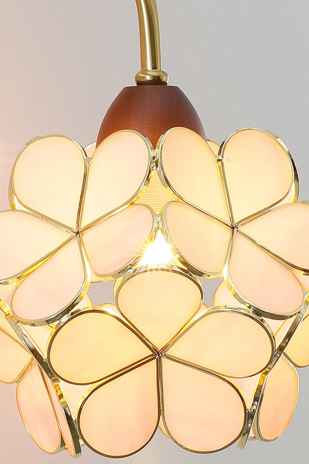 Rosalind Petal Glass Botanical Wall Lamp | Glass, Metal, Wood | Close-up focus on the fully illuminated warm yellow glass flower variant radiating a cozy vintage glow | Detail shot | Samu Lamp