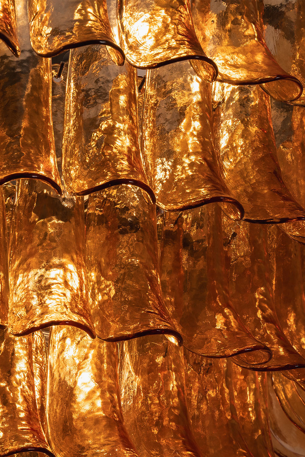 Rouveline Rippled Amber Glass Cone Chandelier | Rippled Amber Glass and Metal | Macro shot highlighting the textured rippled amber glass grain | Samu Lamp