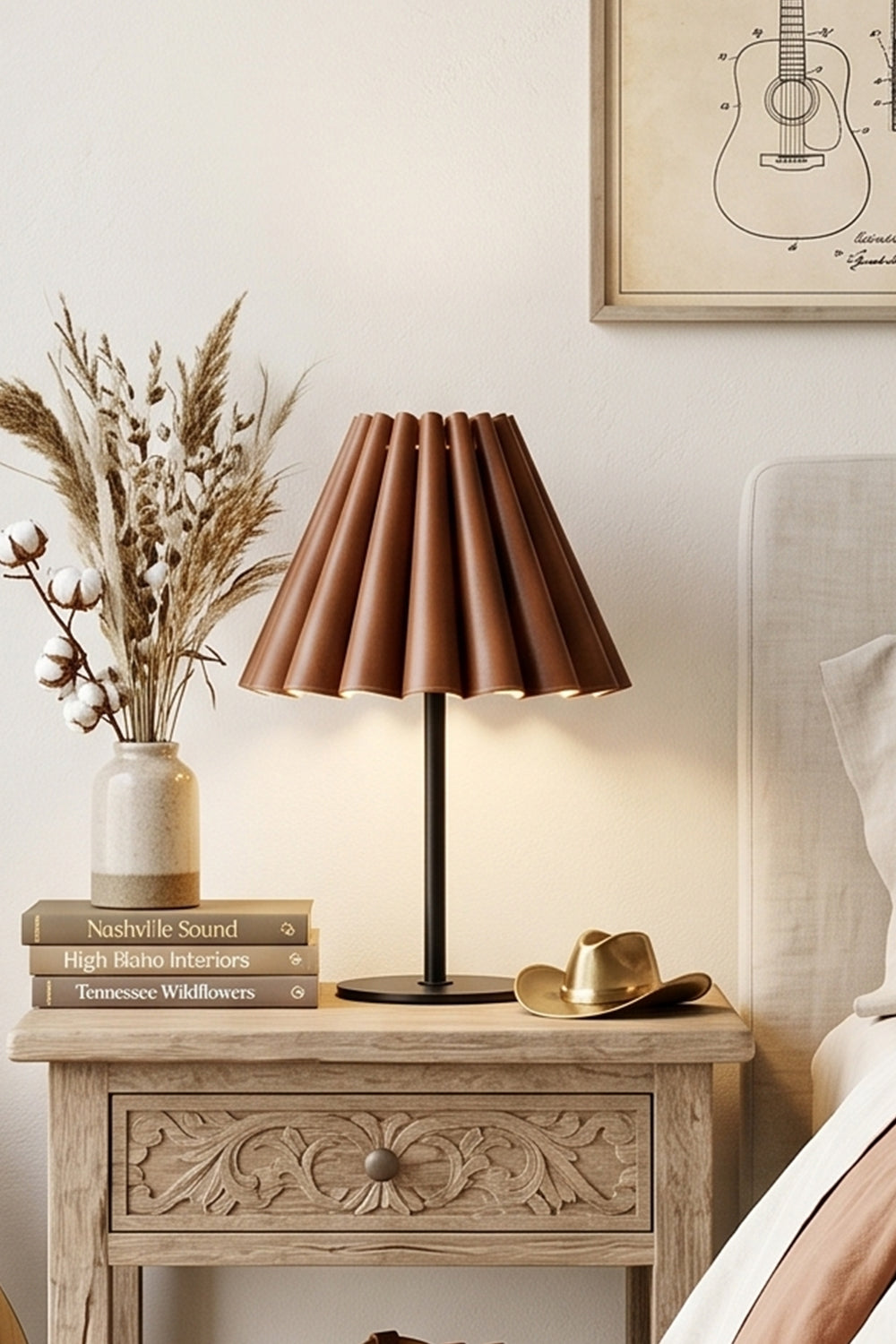 Rowan Leather Pleated Table Lamp | Leather, Metal | Set on a carved vintage light wood nightstand next to dried pampas grass decor in a cozy bedroom | Samu Lamp