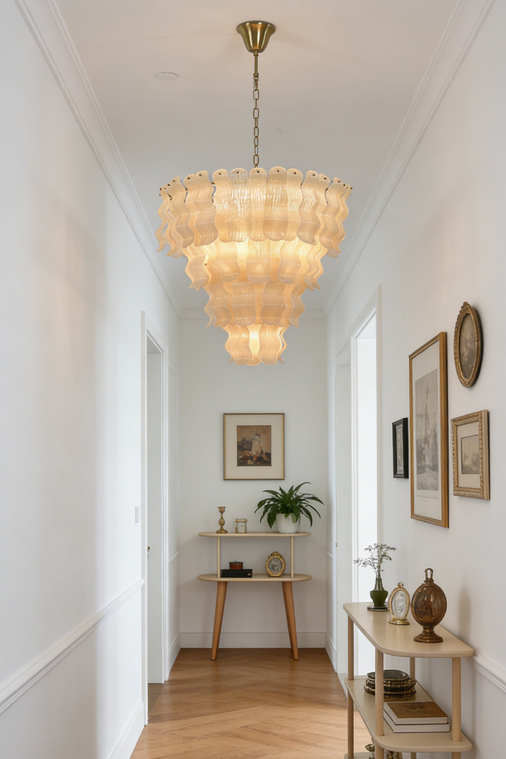 Elegant glass tiered chandelier | Metal | Glass | Hanging in a bright hallway with herringbone wood floors | Samu Lamp