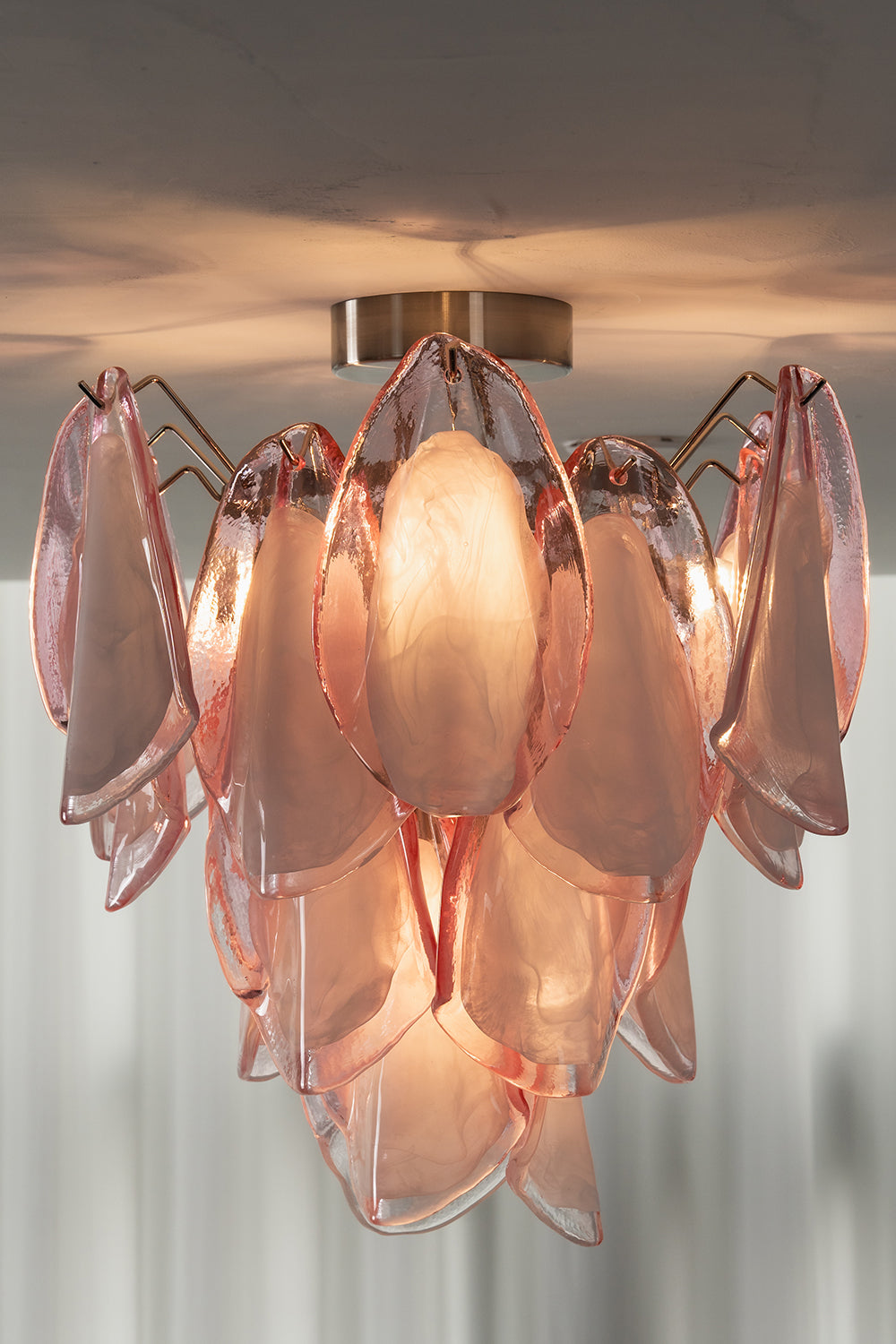 Close-up of lit Seraph petal glass light on a ceiling | Glass, Metal | Showing the warm glow and petal texture | Samu Lamp