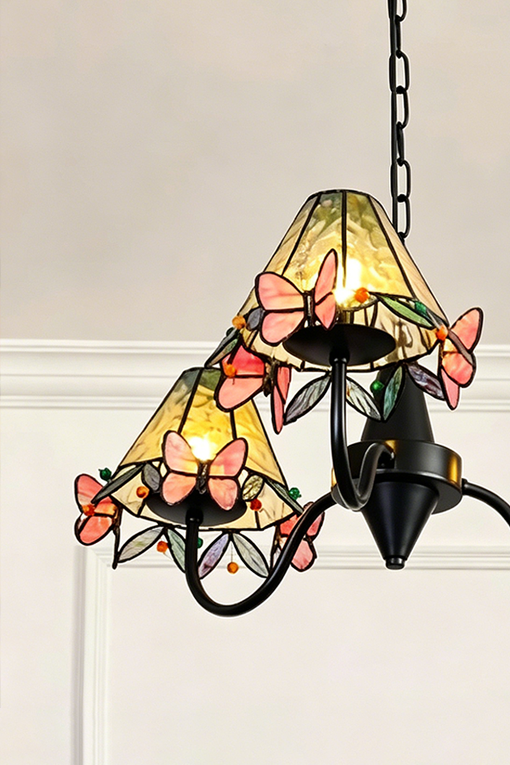 Seraphina Stained Glass Chandelier | Glass, Metal | Detailed side perspective of the illuminated stained glass shades highlighting the layered butterflies | Detail shot | Samu Lamp