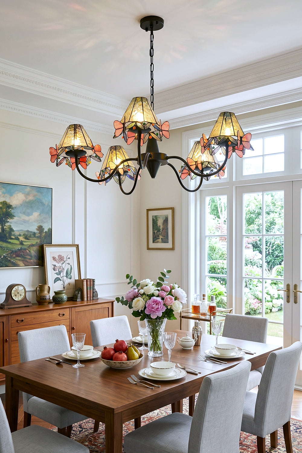 Seraphina Stained Glass Chandelier | Glass, Metal | Suspended over a wooden dining table and grey upholstered chairs in a bright modern dining area with a large window | Samu Lamp