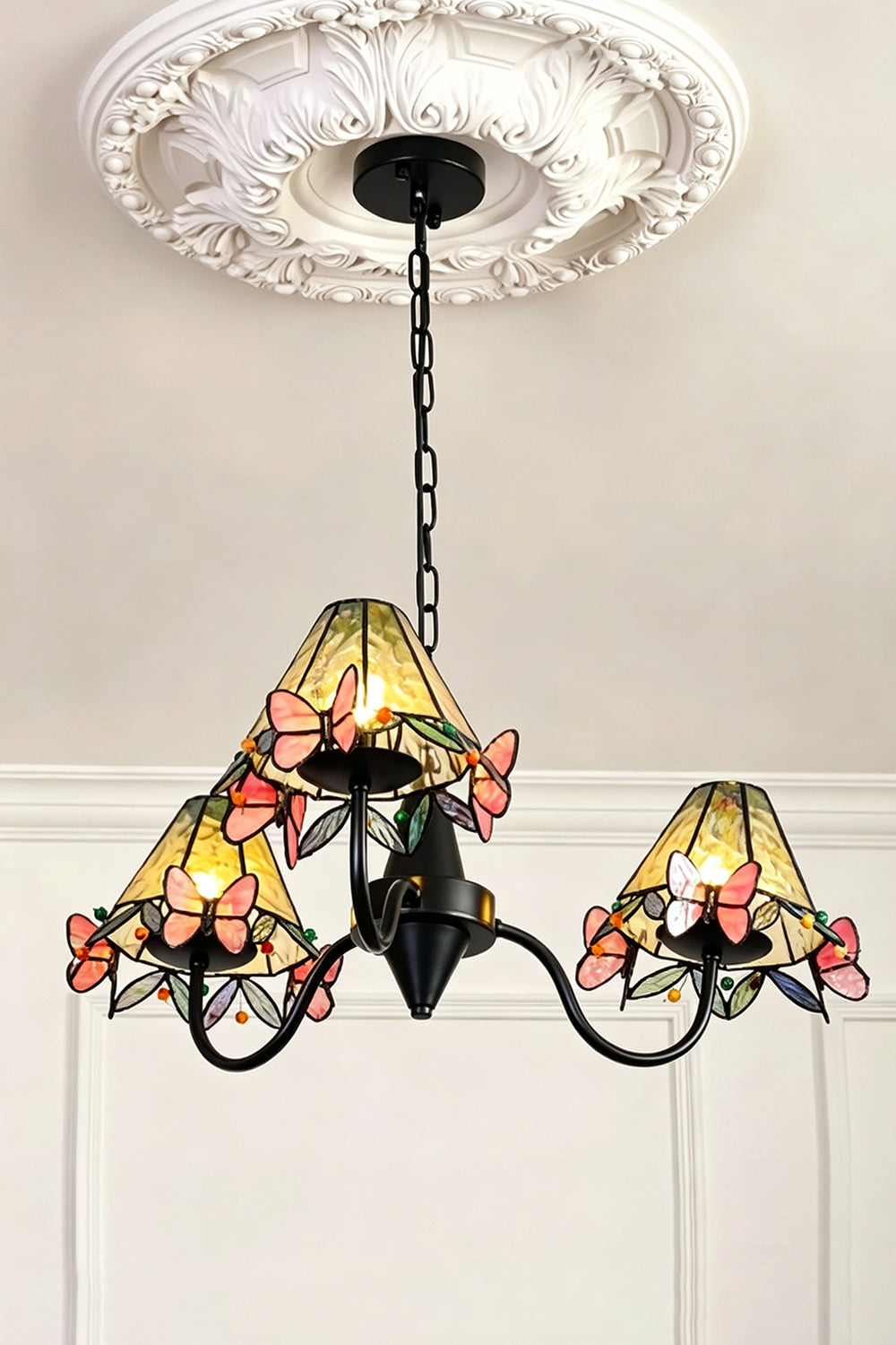 Seraphina Stained Glass Chandelier | Glass, Metal | Low-angle view of the fully lit multi-light chandelier hanging from a decorative white plaster ceiling rose | Samu Lamp