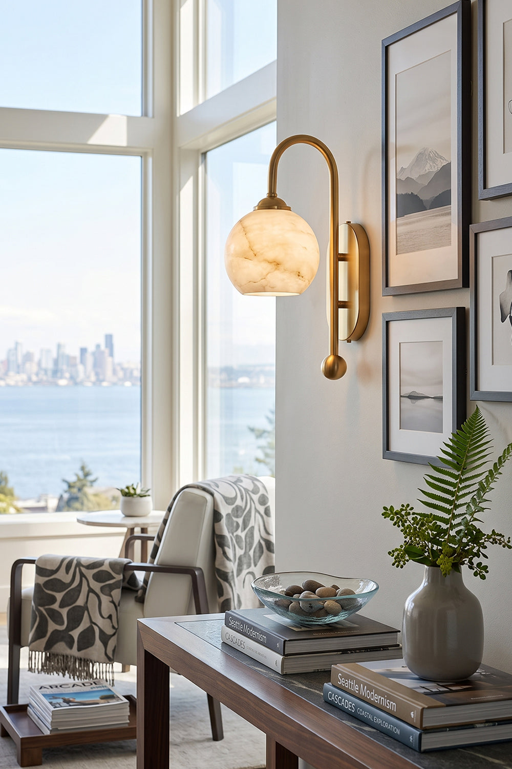 Seraphine Alabaster Globe Wall Sconce illuminating a bright living space with scenic views and stylish decor.
