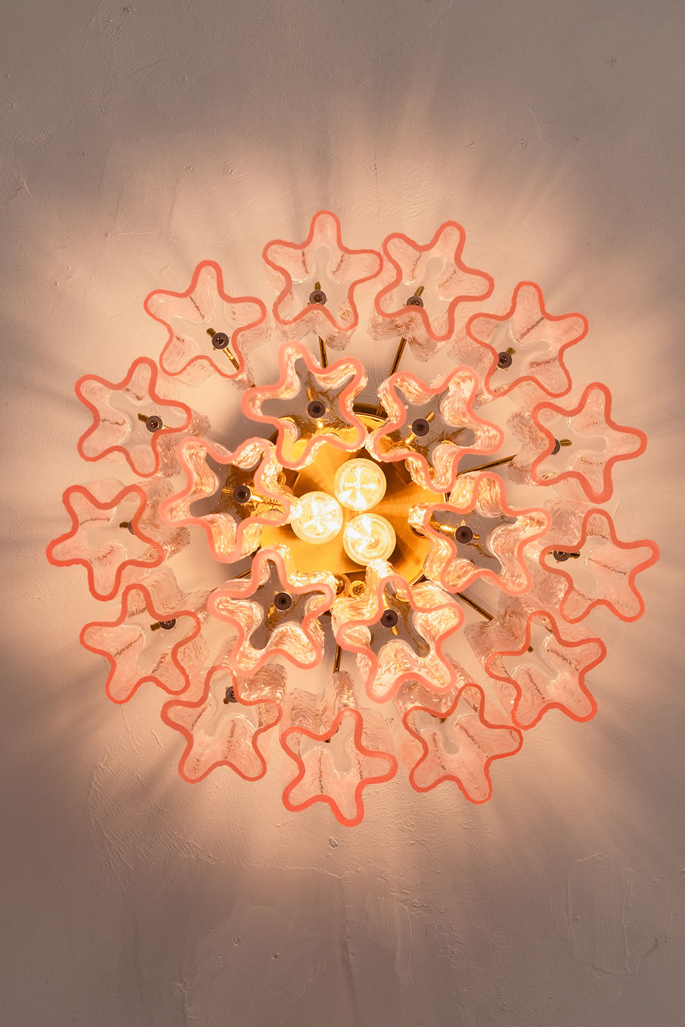Seraphine Starburst Glass Tube Ceiling Light | Pink Glass and Brass | Bottom-up perspective showing the starburst light shadow pattern on the ceiling | Samu Lamp