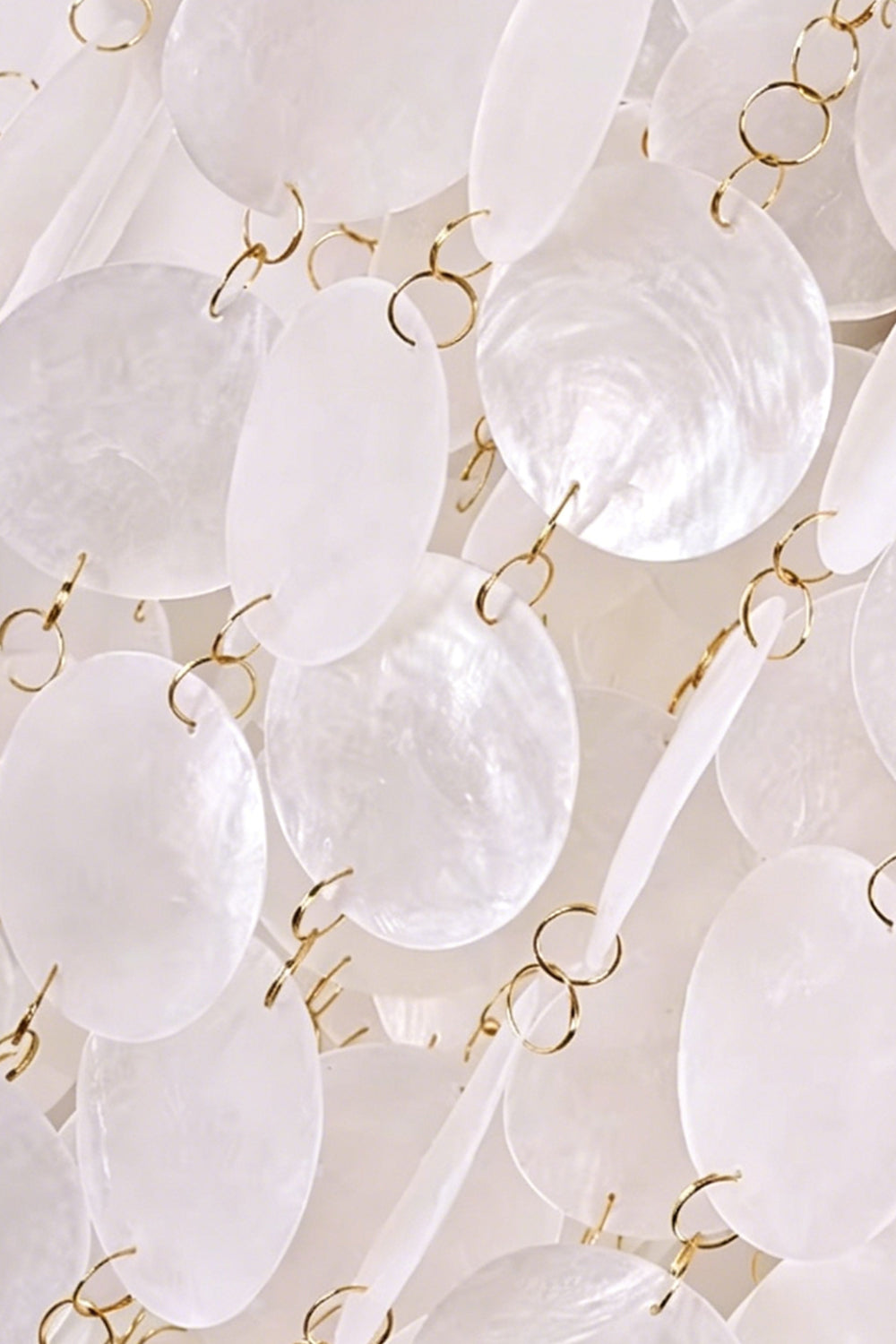 Close-up of cascading shell pieces | Shell | Iron | Detail of metal rings connecting white shell discs | Samu Lamp