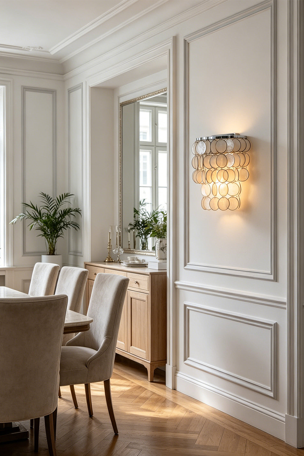 Round Capiz shell wall lamp | Shell | Iron | Mounted on a white paneled wall in a traditional dining room | Samu Lamp