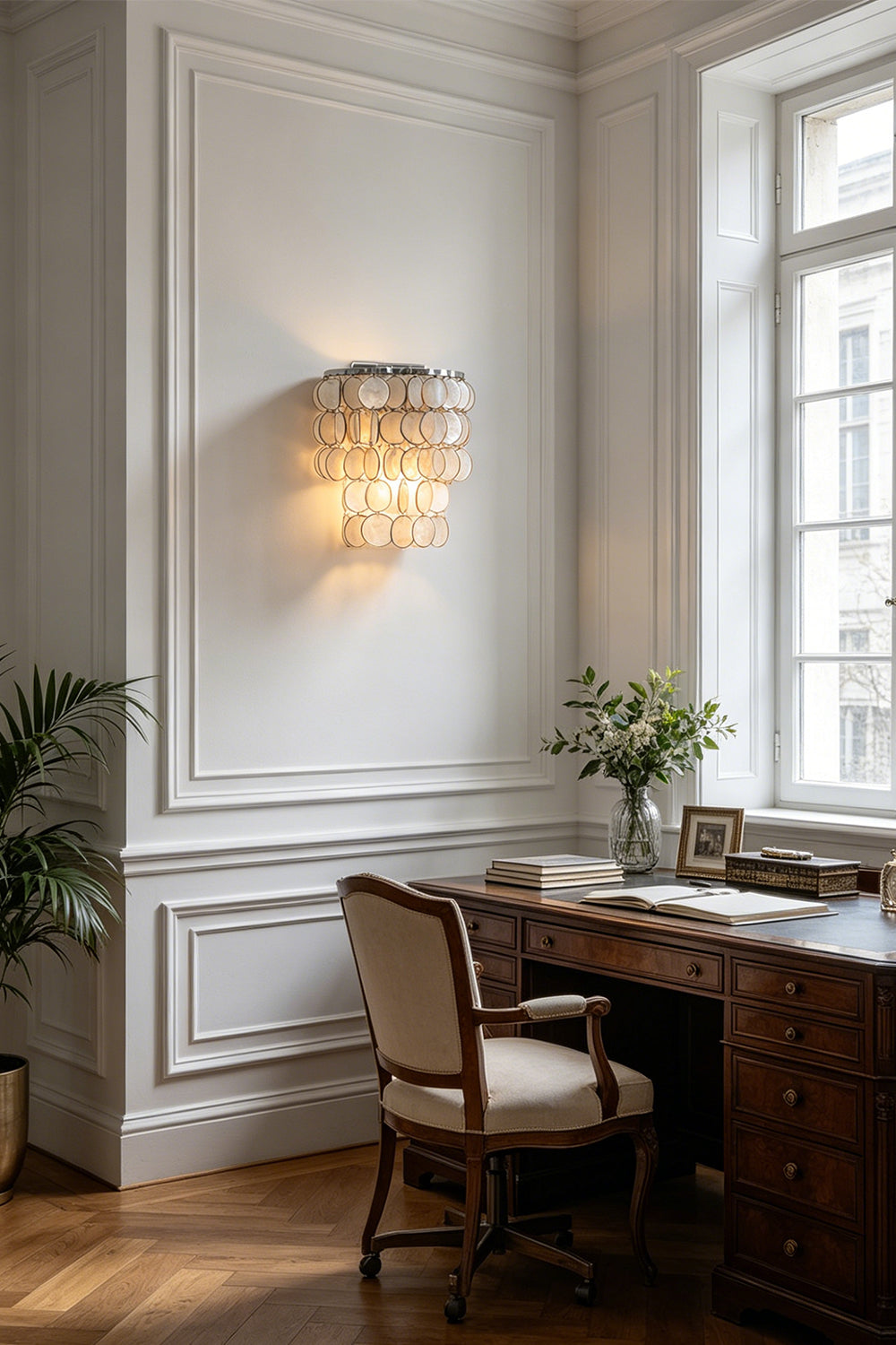 Shimmering Capiz wall lamp for home office | Shell | Iron | Installed above a vintage wooden desk by a window | Samu Lamp